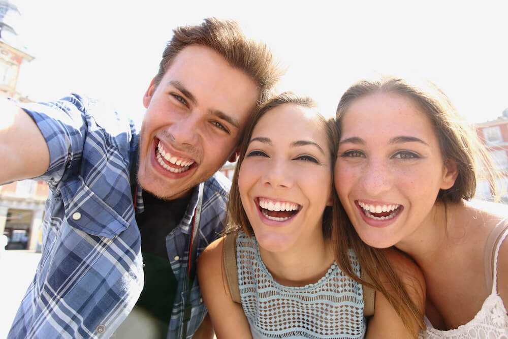 Selfie image of young teens smiling.