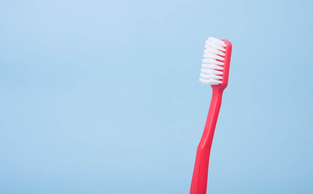 A red toothbrush ready to fight plaque.